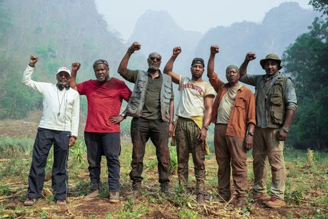men in jungle with fists raised