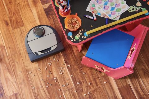 neato robot vacuum picking up cereal on floor