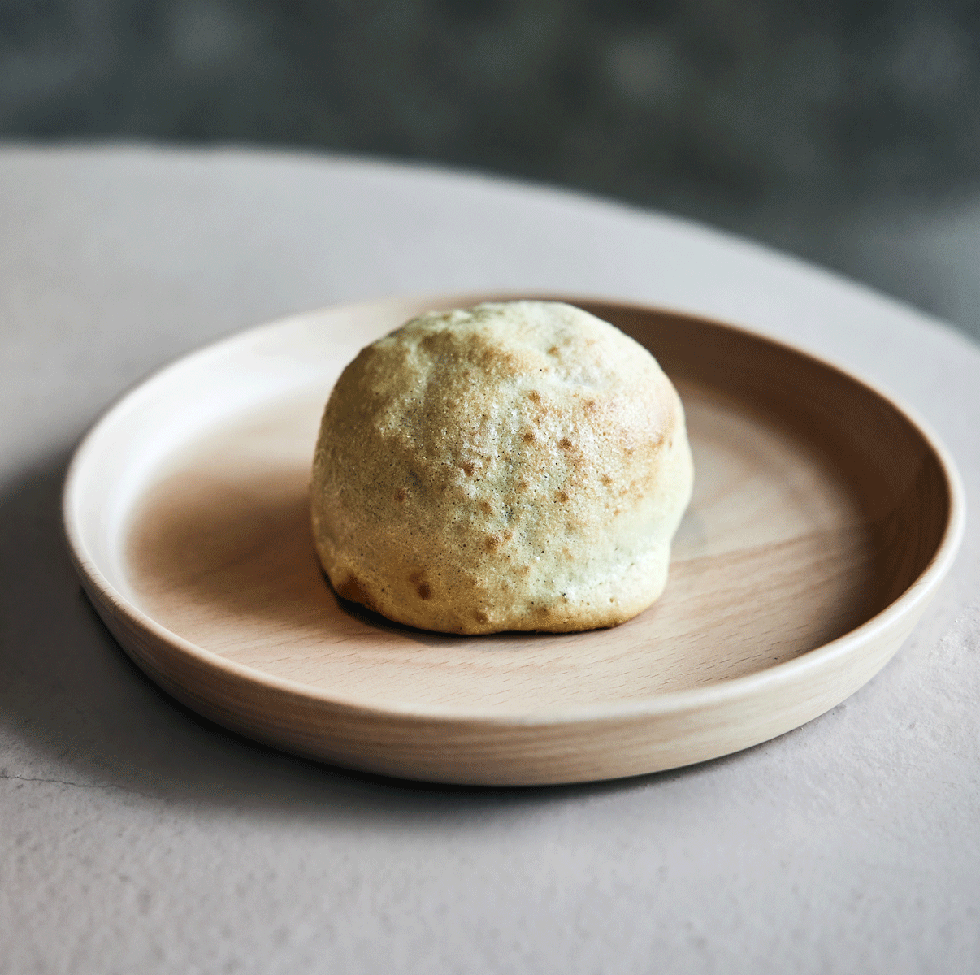 a small round pastry on a wooden plate