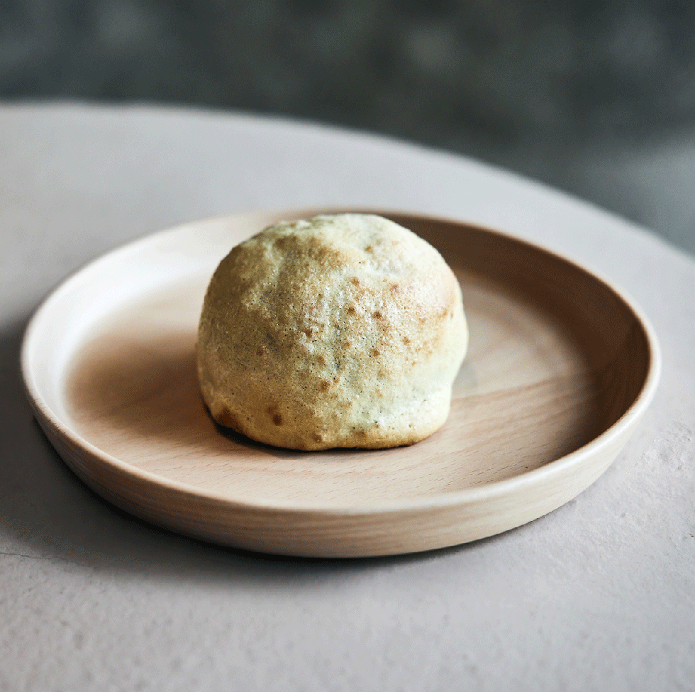 a small round pastry on a wooden plate