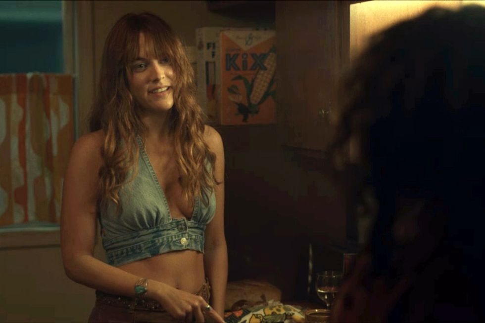 riley keough in a denim bra and tan pants in daisy jones and the six