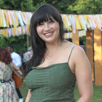 daisy lowe smiling at an outdoor event with bunting in the background