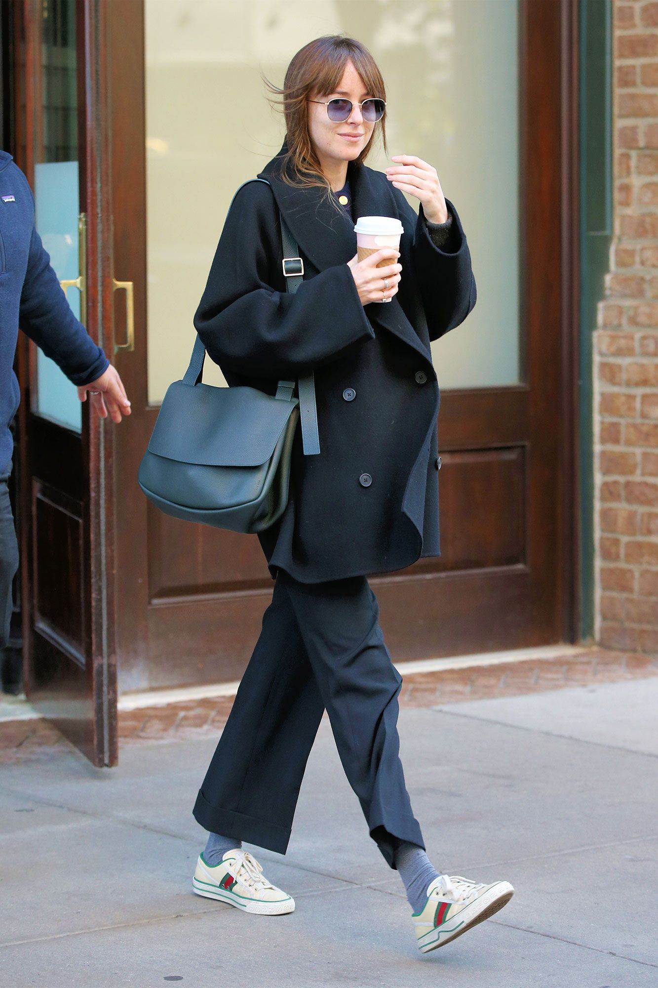 Dakota Johnson luce pantalones sastre con zapatillas blancas