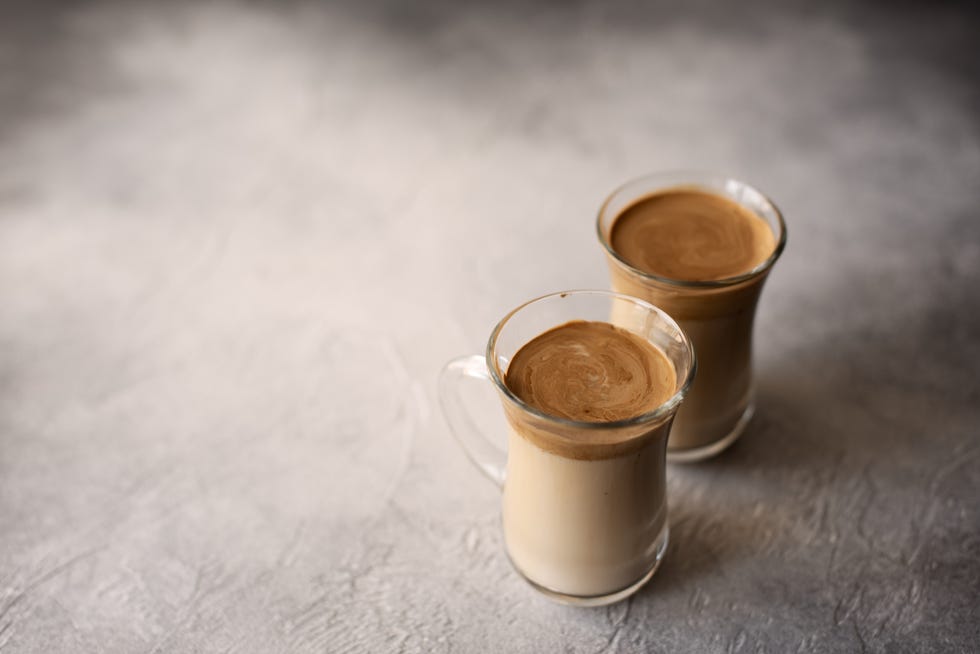 dalgona coffee in a transparent glass on a marble background