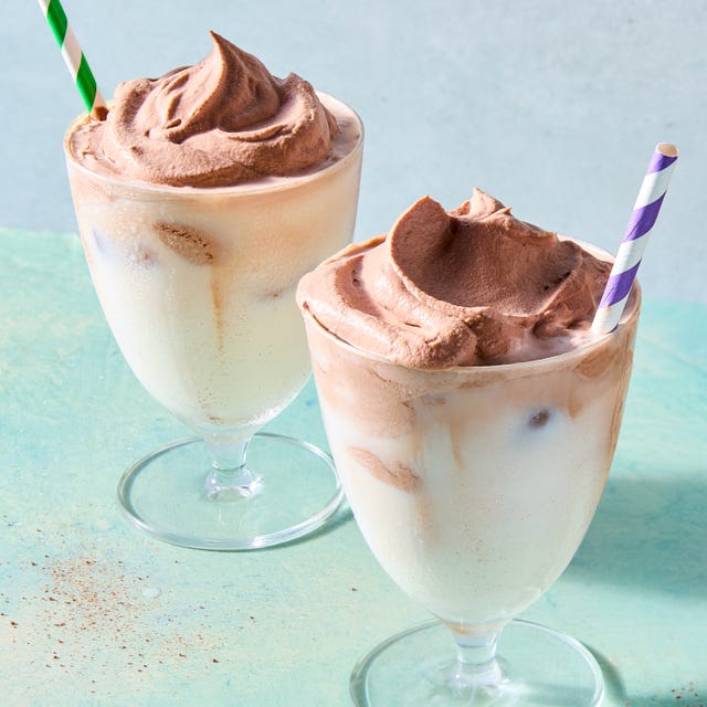 whipped chocolate in a frosted glass with a blue and white straw