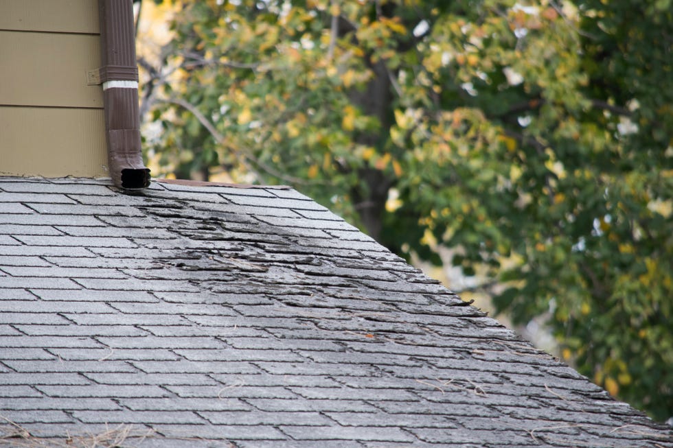 damaged and old roofing shingles on a house