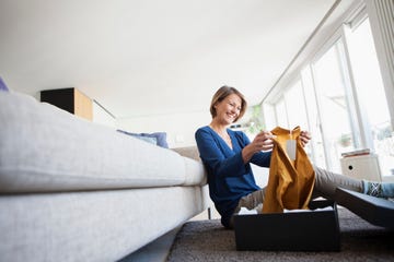 damart partnership woman holding shirt out of a box