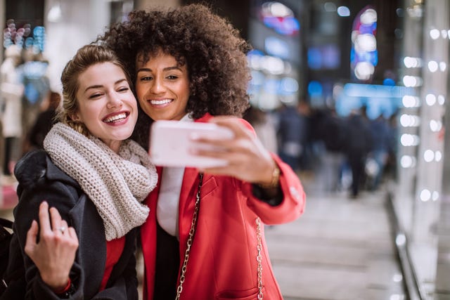 beautiful young women having fun, making selfie on shopping day in christmas time