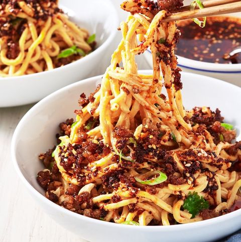 dan dan noodles topped with chili oil, sesame seeds, and scallioons