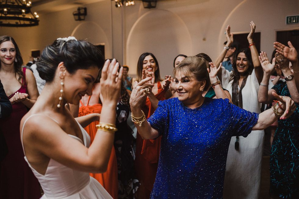 woman in wedding dress dancing with grandmother