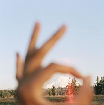 a hand with a sunset in the background