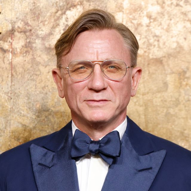 daniel craig poses in blue suit and glasses