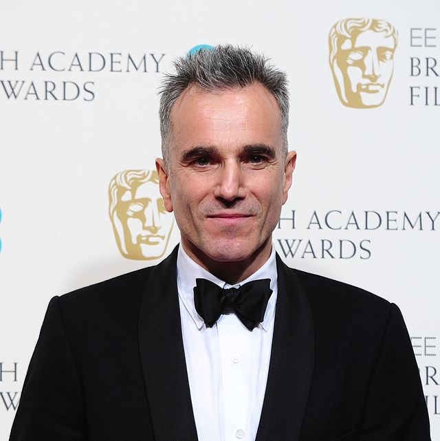 daniel day lewis wears a black tuxedo and smiles at the camera