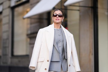 mujer con gafas de sol y chaqueta blanca