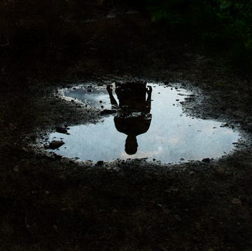 A dark, atmospheric edit of a mysterious man silhouetted in a puddle.. With a grunge, vintage edit. a dark, atmospheric edit of a mysterious man silhouetted in a puddle with a grunge, vintage edit
