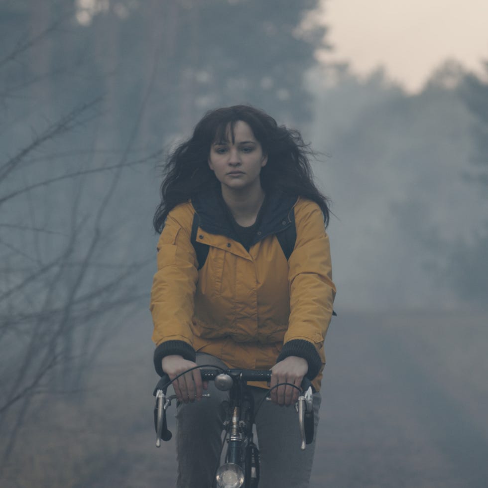cyclist navigating through a foggy wooded path cyclist navigating through a foggy wooded path