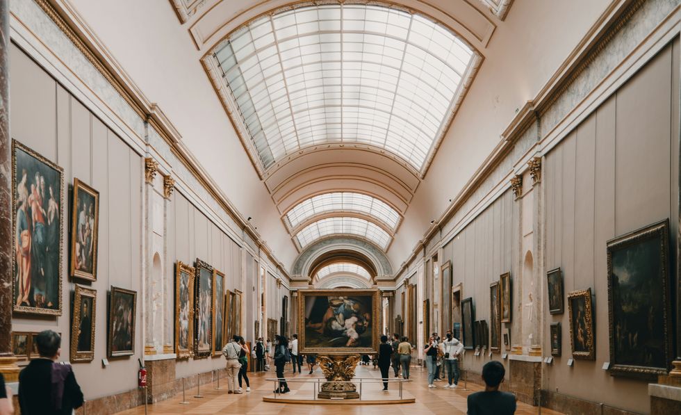 a large room with art on the walls and people walking around