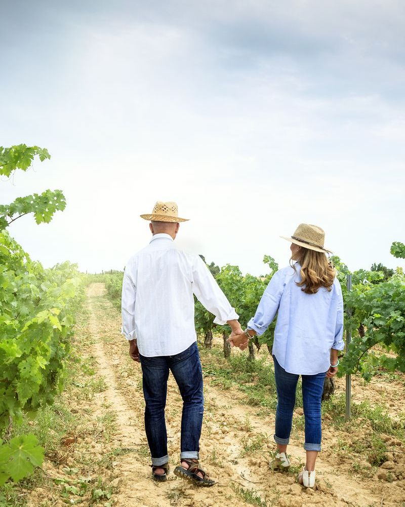 date night ideas with a couple holding hands walking through vineyard