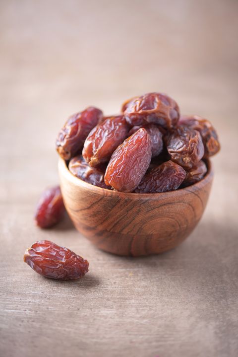 dried dates in wooden bowl