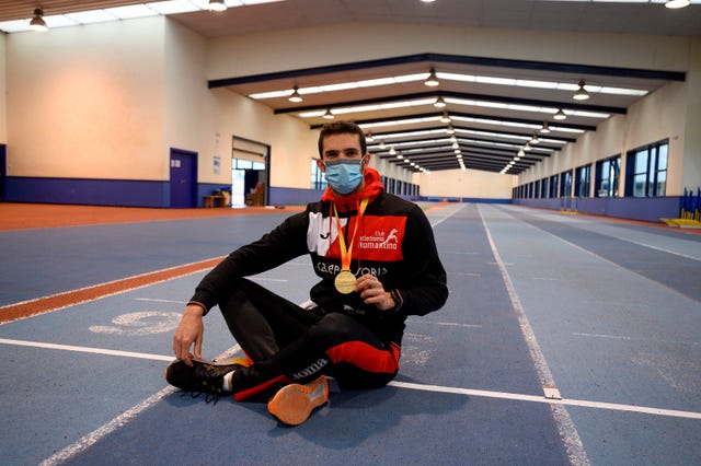 david bolado posa sentado con su medalla de oro de campeón de españa de salto de altura 2021 en el módulo cubierto de santander
