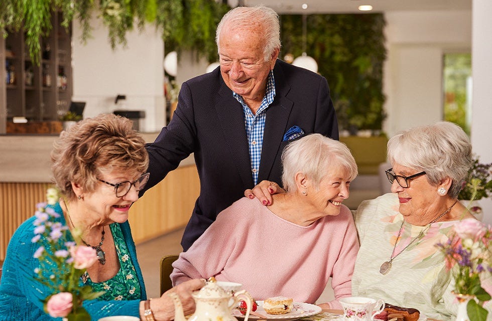 a gathering of older adults enjoying tea and pastries