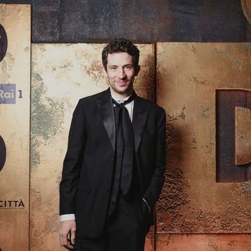 a person in a suit standing in front of a wall with numbers