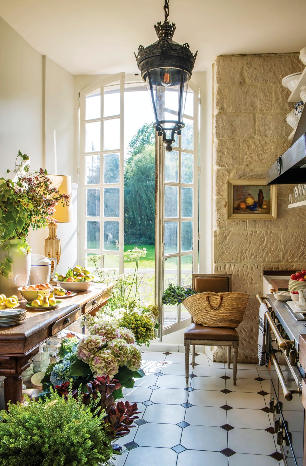 a french country style kitchen with doors flung open to the garden
