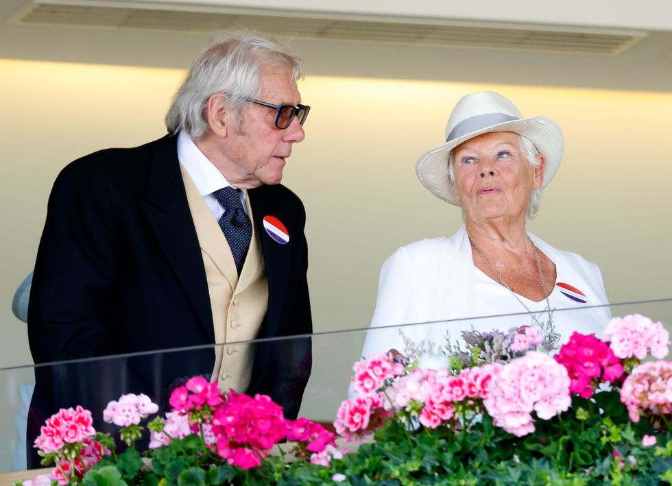 judi dench wearing a hat and leaning to the right as she talks to her partner
