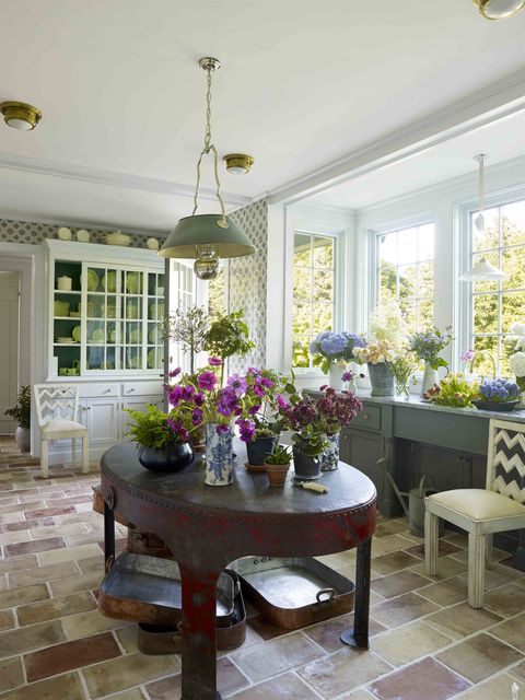 reclaimed terra cotta flooring and custom blue and white wall tiles and vases of flowers everywhere