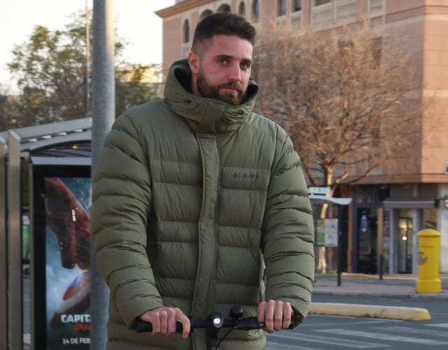 el novio de anabel pantoja con un abrigo verde montado en patinete