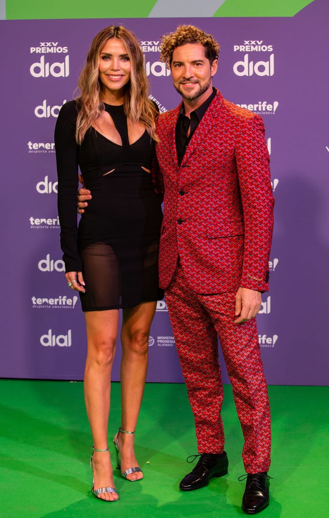 el cantante y su esposa posan abrazados en la alfombra verde de estos premios musicales