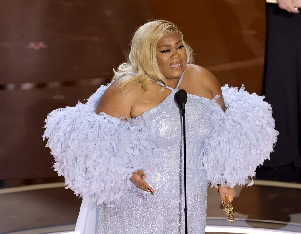 a woman wearing a white dress and holding a microphone a woman wearing a white dress and holding a microphone