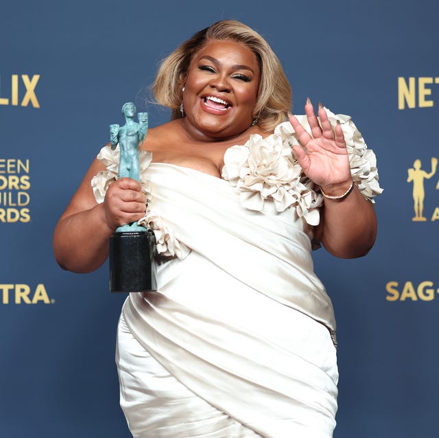 davine joy randolph smiling at a camera and waving as she holds a screen actors guild trophy in her other hand