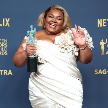 davine joy randolph smiling at a camera and waving as she holds a screen actors guild trophy in her other hand