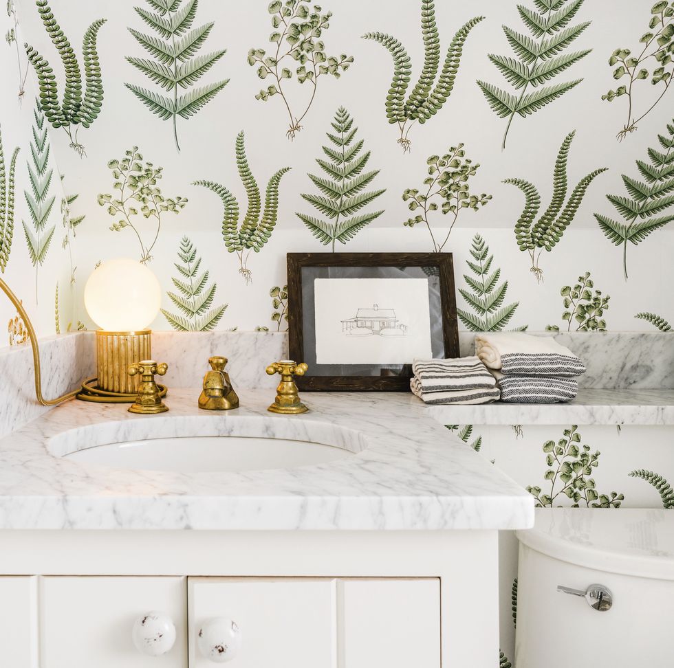 powder room with white vanity and fern wallpaper