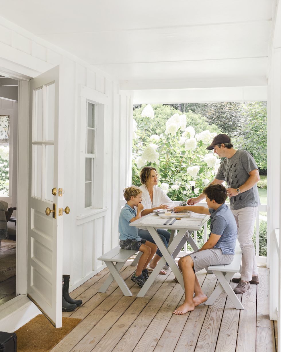 rustic white porch with family sitting at picnic table