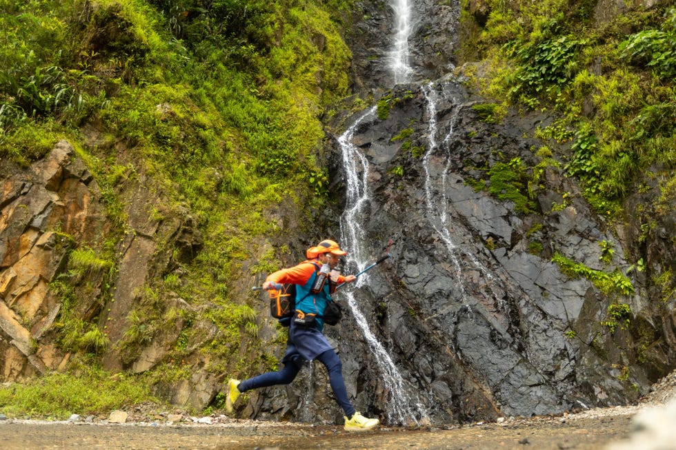 man running over a stream in a jungle