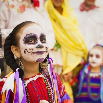 children dressed in day of the dead costumes and skull face paint