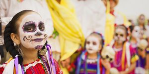 children dressed in day of the dead costumes and skull face paint
