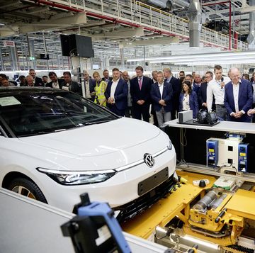volkswagen id7 sedan sits at the end of the assembly line with workers standing around it