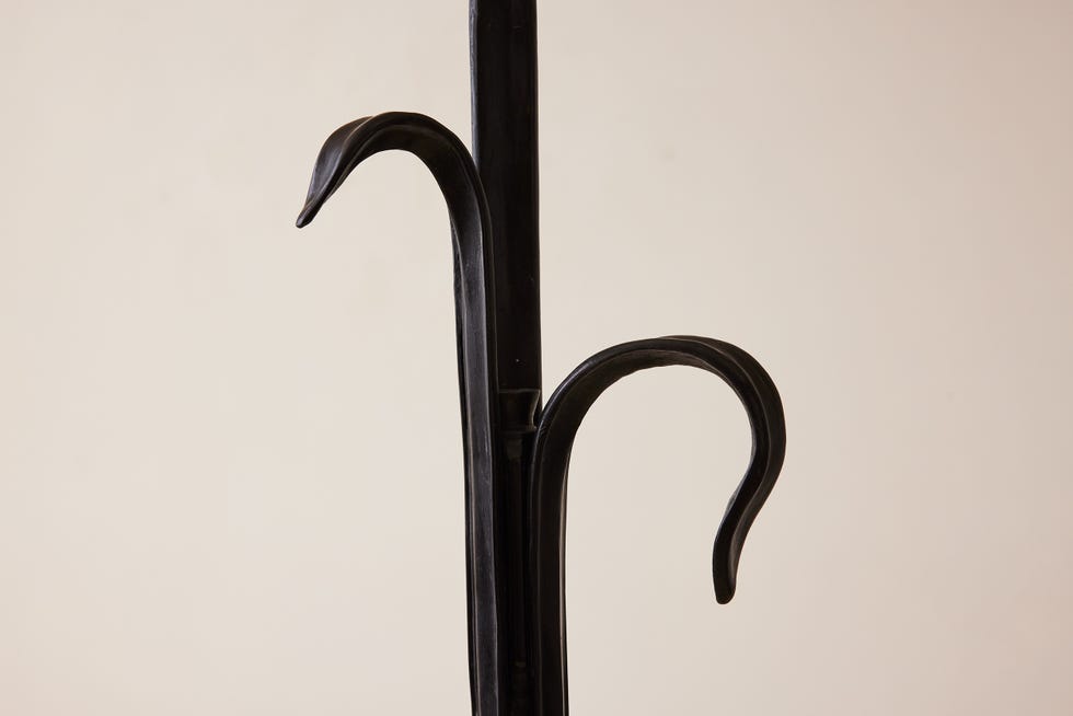 Umbrella stand with decorative hooks.
