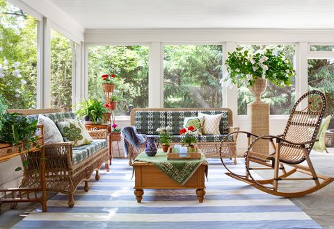 screened in porch, blue and white striped rug, wicker chairs and sofa with green and white cushions, indoor plants