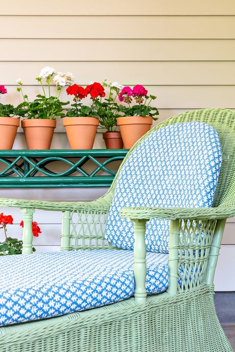 green wicker chair with blue and white seat cushion