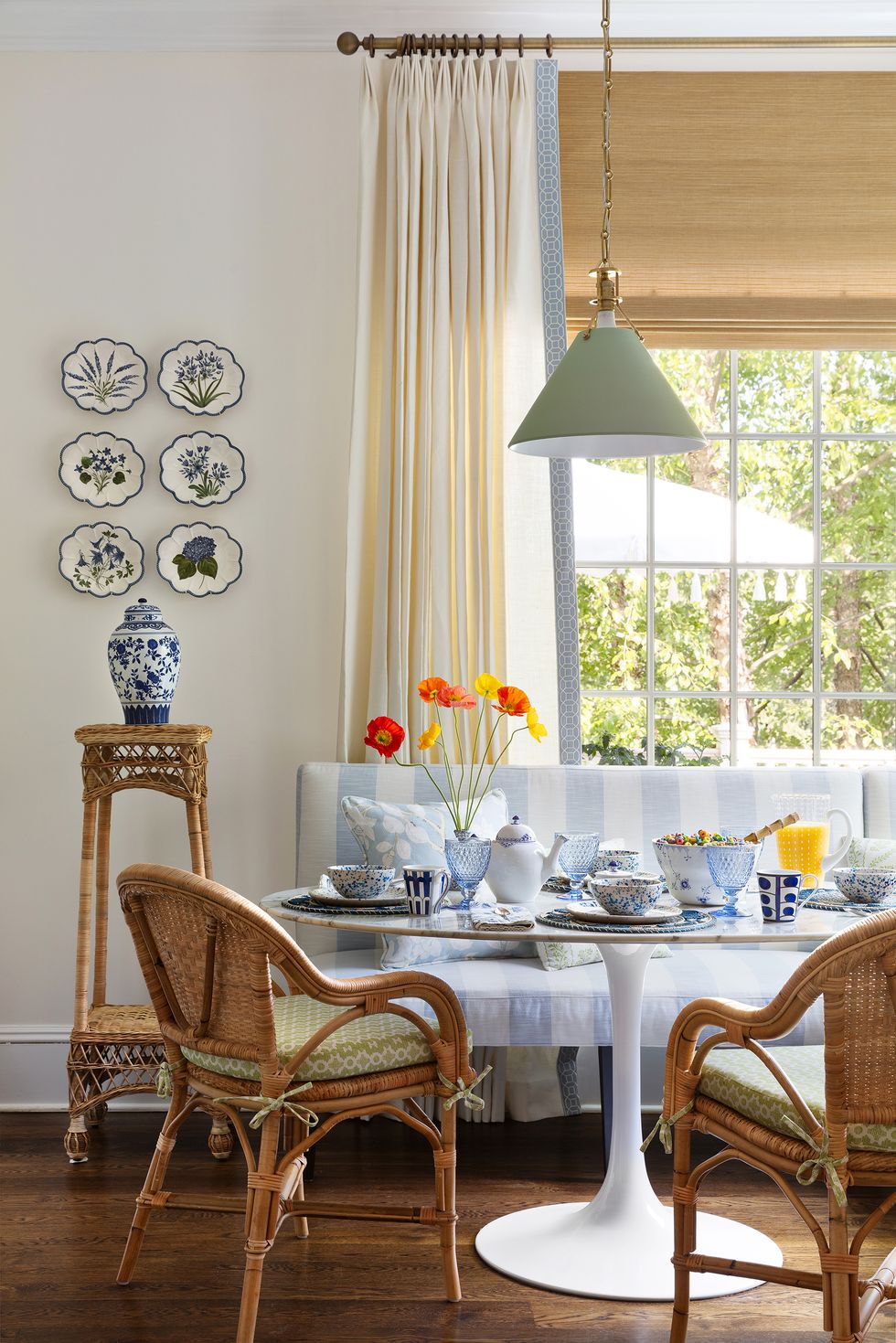 breakfast nook, white and blue striped seat cushions, wicker chairs, cream colored curtains