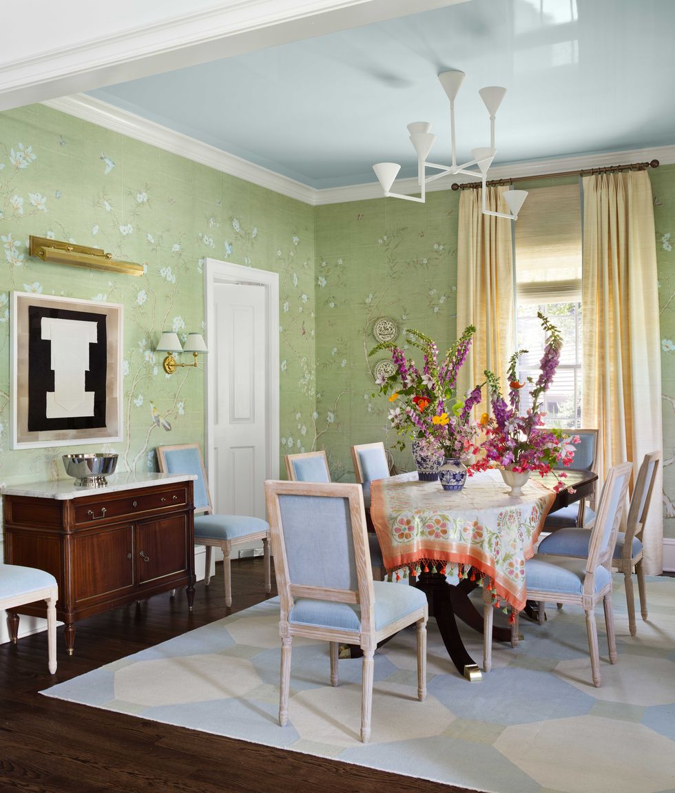 dining room, green wallpaper, blue and white hexagonal rug, white and blue chairs, cream curtains