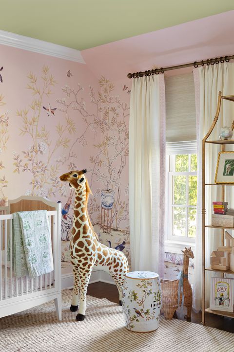 pink wallpaper, giraffe stuffed toy, nursery cot, cream rug