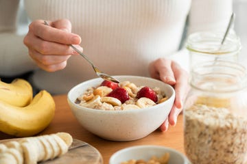 een vrouw eet havermout met banaan en aardbei