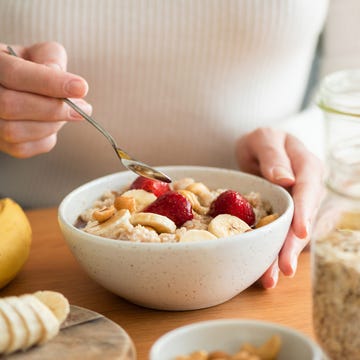 Beste voeding voor een lange duurloop een vrouw eet havermout met banaan en aardbei