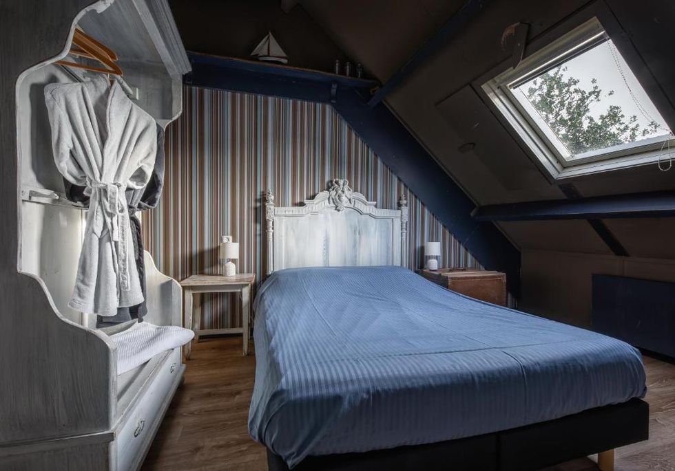 slaapkamer, streepjesbehang, blauw beddengoed, klassiek bed