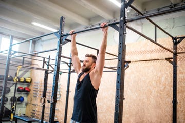 een man doet dead hangs in de sportschool